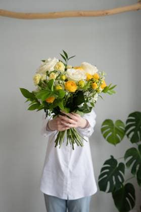 Creative Highlights Symbolbilder PR_ID13186_3100_LivingRoom.jpg, MR_ID13186_13062_AlenaZhdanova.jpg Unrecognizable female in white shirt holding bouquet of fresh flowers while standing against gray wall near green plant, Property released Model Released LiliyaSolopova_ID13186_402429_029 Copyright: xLiliyaxSolopovax