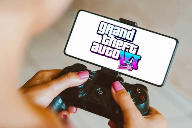 Photo illustration in Brazil - 5 Dec 2023 In this photo illustration, the Grand Theft Auto VI (GTA 6) logo is displayed on a smartphone screen as a person plays on a gaming gamepad. Brazil Copyright: xRafaelxHenriquex xSOPAxImagesx RAFAPRESS_05122023-09338