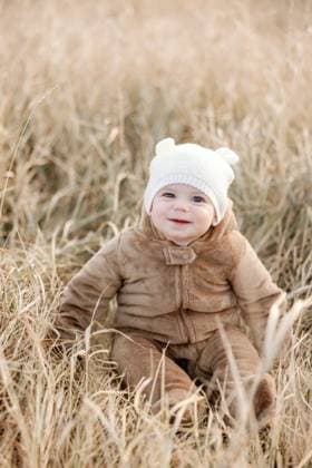 Creative Highlights Symbolbilder Smiling 9-month-old baby in bear suit amid fall grass Calgary, Alberta, Canada R_CUYS231205-1297301-01 ,model released, Symbolfoto