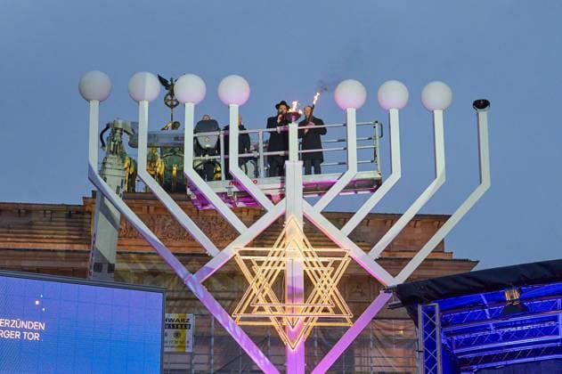 Bilder des Jahres 2023, News 12 Dezember News Themen der Woche KW49 News Bilder des Tages Vor dem Brandenburger Tor in Berlin wird am Donnerstag (07.12.2023) das erste Licht an einem zehn Meter hohen Chanukka-Leuchter entzuendet (Foto: Feierliche Zeremonie der Entzuendung am Nachmittag durch Rabbiner Yehuda Teichtal und Bundeskanzler Olaf Scholz). Das achttaegige juedische Lichterfest Chanukka (hebraeisch: Weihung) beginnt in diesem Jahr am 7. Dezember. Bis zum 15. Dezember wird an dem Leuchter jeden Tag mit Einbruch der Dunkelheit ein neues Licht entzuendet. Zu den Gaesten der Zeremonie gehoerten neben Bundeskanzler Olaf Scholz (SPD), Berlins Regierender Buergermeister Kai Wegner (CDU), der israelische Botschafter in Deutschland, Ron Prosor, und die Familie der von Hamas-Terroristen entfuehrten Deutsch-Israelin Yarden Roman. (S Copyright: epd-bild ChristianxDitsch epd-Chanukka_Lichterzuenden2-kopieren