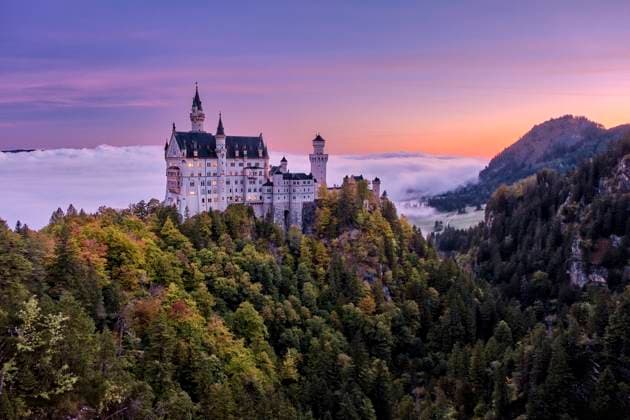 The castle Neuschwanstein, seen from the bridge Marienbrücke at sunrise in autumn, rising out of the fog. Hohenschwangau Bavaria Germany FB_2023_2866