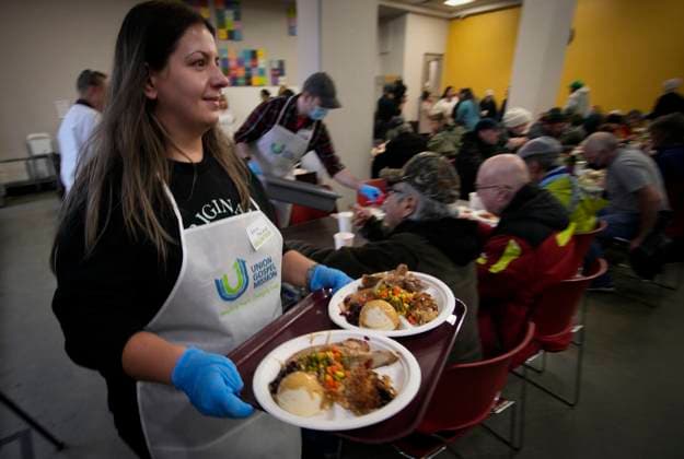 (231210) -- VANCOUVER, Dec. 10, 2023 -- A volunteer serves food during the annual Christmas dinner at Union Gospel Mission (UGM) in Vancouver, British Columbia, Canada, on Dec. 9, 2023. (Photo by Xinhua) CANADA-VANCOUVER-CHRISTMAS-CHARITY DINNER LiangxSen 
