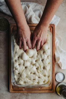 Creative Highlights Symbolbilder Hands making holes in risen focaccia dough shot from above. Kingston, Ontario, Canada CR_DOHO231207H-1299946-01 ,model released, Symbolfoto