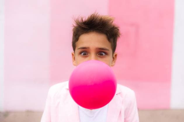 Creative Highlights Symbolbilder Young boy all pink blowing up a balloon in a suit with a funny face United States, California, San Diego CR_CHDO231210-1298527-01 ,model released, Symbolfoto