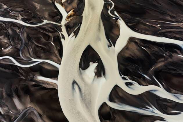 Captivating aerial shot capturing the intricate patterns and contrasting colors of an Icelandic river basin snaking through dark volcanic soil Model Released DavidJerez_ID17788_536946_045 Copyright: xDavidxJerezx