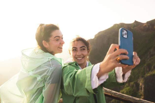 Creative Highlights Symbolbilder Cheerful young woman taking selfie with female friend through smartphone at mountain peak during sunrise at weekend getaway Model Released EricPanades_ID17285_525799_006 Copyright: xEricxPanadesx RECORD DATE NOT STATED