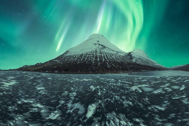 Mesmerizing aurora borealis dancing over a snowy mountain in the tranquil Icelandic landscape. Model Released JuanLopez_ID17877_538971_004 Copyright: xJuanxLopezx
