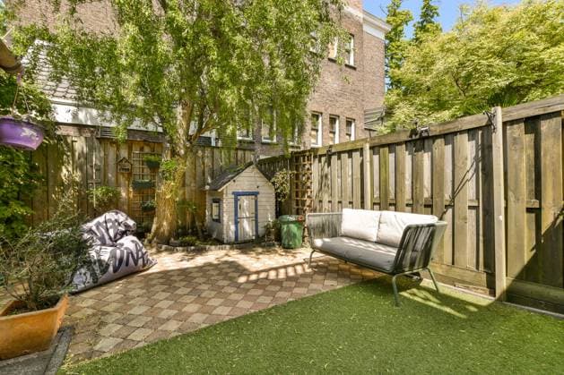 PR_ID16450_4789_Kerkstraat23.jpg Couch by dollhouse and beanbag with trees and plants in backyard with wooden fence on sunny day, Property released Model Released ProCreators_ID16450_500077_001 Copyright: xProxCreatorsx RECORD DATE NOT STATED