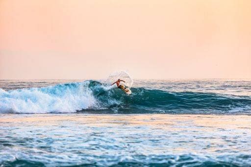 A shot of a male surfing on the sea during daytime 28305 RECORD DATE NOT STATED