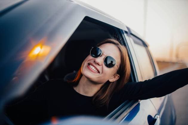 Creative Highlights Symbolbilder Glückliche Autofahrerin mit Sonnenbrille fährt ein Auto und lächelt bei Sonnenuntergang. Glückliche Reise Konzept *** Happy Car driver with Sunglasses drives a Car and smiles at Sunset Happy Trip Concept Copyright: imageBROKER/MikalaixSayevich ibxwsp09937765.jpg ,model released, Symbolfoto ,property released