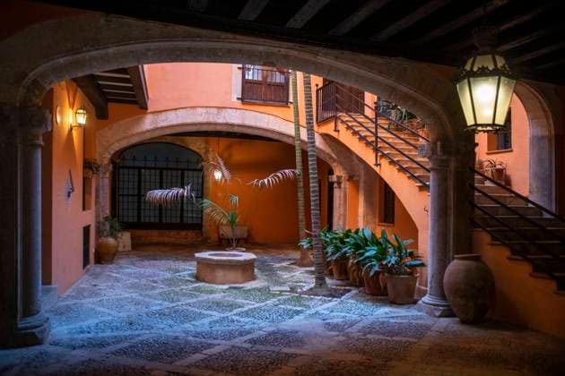 Spain Balearic islands Mallorca Palma de Mallorca Carrer de Can Savella stret Interior of some of the Majorcan patios Mallorca courtyard. Majorcan-style interior patios of some houses on Calle Can Savella. Can Vivot, declared an Asset of Cultural Interest and a Historic-Artistic Monument, has a spectacular stately courtyard populated by three vintage horse-drawn carriages. Behind this impressive entrance hides a no less surprising origin that dates back to the fourteenth century with the union of the raconada d en Berard and l alberg d en ClapÃ s, houses very close to each other. Prior to that, there is an Arab arch that, according to Montaner, is believed to be the roof of some baths. Mallorca Baleares Spain Copyright: xSergixReboredox xVWPicsx SRE-FY0069