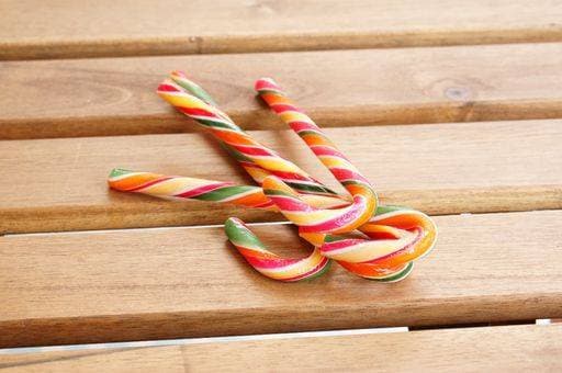 The colorful candy canes on a wooden surface - perfect for background 261123 RECORD DATE NOT STATED