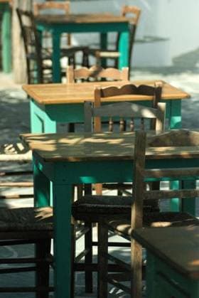 Taverna tables and chairs at a traditional Greek restaurant on the island of Folegandros. Sunlight and shade in the late afternoon. 369238 RECORD DATE NOT STATED