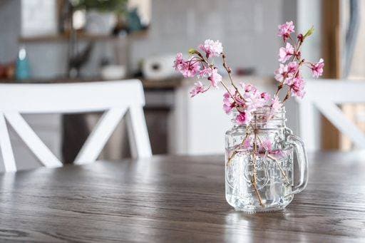 Pink cherry flowers and branches in a glass of water on the table under the lights 376879 RECORD DATE NOT STATED