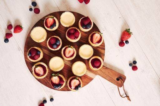 A high angle shot of cheese cupcakes with fruit jelly and fruits on a wooden plate with a white background 378125 RECORD DATE NOT STATED