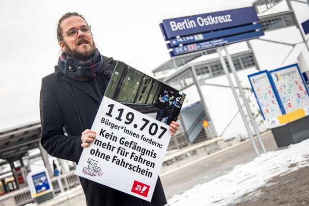 Organisator Arne Semsrott mit einem Plakat vor der Protestlesung gegen die Kriminalisierung des Fahrens ohne Ticket am Ostkreuz in Berlin am 5. Dezember 2023. Protestlesung gegen die Kriminalisierung des Fahrens ohne Ticket *** Organizer Arne Semsrott with a poster in front of the protest reading against the criminalization of driving without a ticket at Ostkreuz in Berlin on 5 December 2023 Protest reading against the criminalization of driving without a ticket