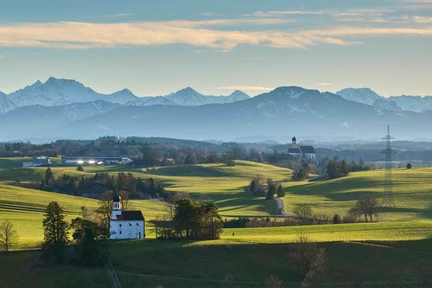 Bavarian landscape with city view, St.Martin church (background) and Loreto Kapelle with Plague cemetery in the evening, short before sunset in Marktoberdorf, Germany, Dec 25, 2023.