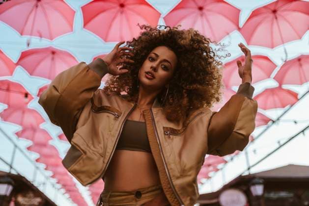 Creative Highlights Symbolbilder Beautiful woman dancing with arms raised under pink umbrellas model released, Symbolfoto, ANNF00630