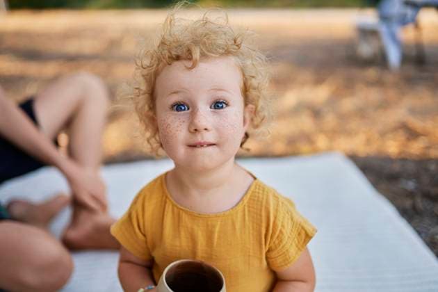 Creative Highlights Symbolbilder Cute girl with tea cup sitting on picnic blanket in park model released, Symbolfoto, ANNF00676