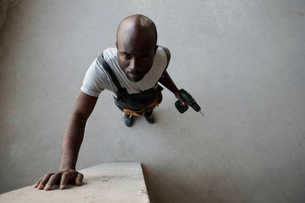 Creative Highlights Symbolbilder Construction worker holding drill machine and touching wall at site model released, Symbolfoto property released, DSHF01371