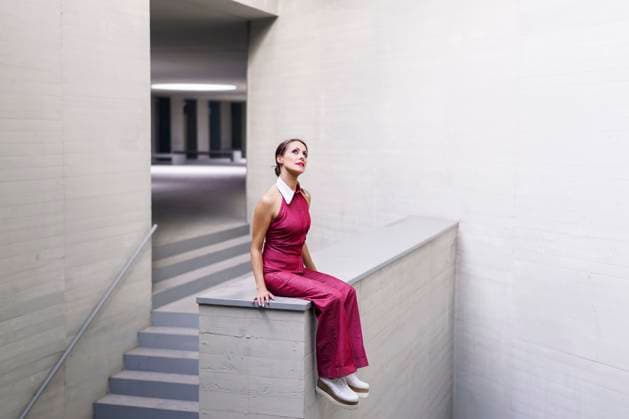 Creative Highlights Symbolbilder Contemplative woman wearing pink jumpsuit and sitting on wall near staircase model released, Symbolfoto, JSMF02954