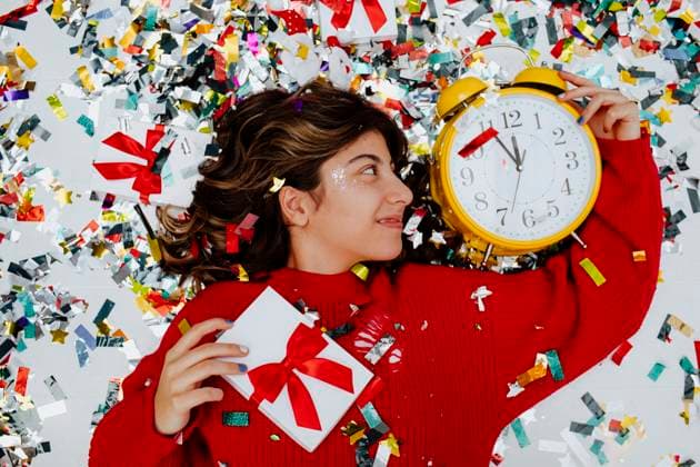 Creative Highlights Symbolbilder Happy girl lying near confetti with clock and gift boxes model released, Symbolfoto property released, MDOF01737