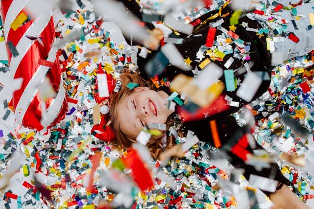 Cheerful girl lying under falling confetti on floor model released, Symbolfoto property released, MDOF01744