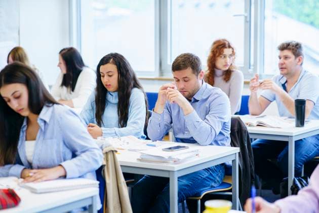 Multi-ethnic students studying at desk in classroom model released, Symbolfoto property released, NJAF00641