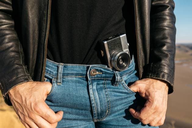 Close-up of a vintage camera tucked into the denim jeans of a man wearing a black leather jacket, no face shown Model Released SergioVictorVega_ID18085_543941_009 Copyright: xSergioxVictorxVegax