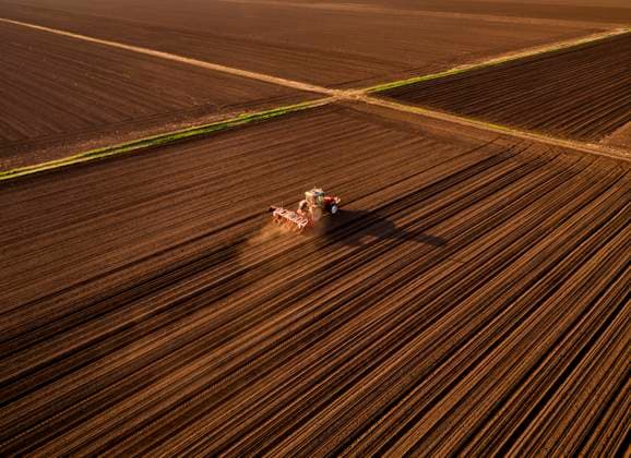 Serbia, Vojvodina Province, Aerial view of tractor sowing seeds in plowed corn field model released, Symbolfoto, NOF00821