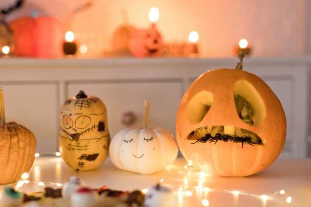 Pumpkin decorations near string light on table at home property released, ONAF00707