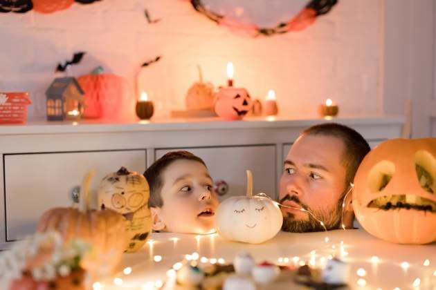Father and son looking at each other near Halloween decoration on table model released, Symbolfoto property released, ONAF00709