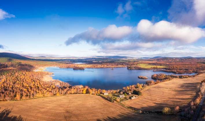 UK, Scotland, Aerial view of fields surrounding Loch Kinord in autumn, Aboyne Scotland United Kingdom SMAF02702