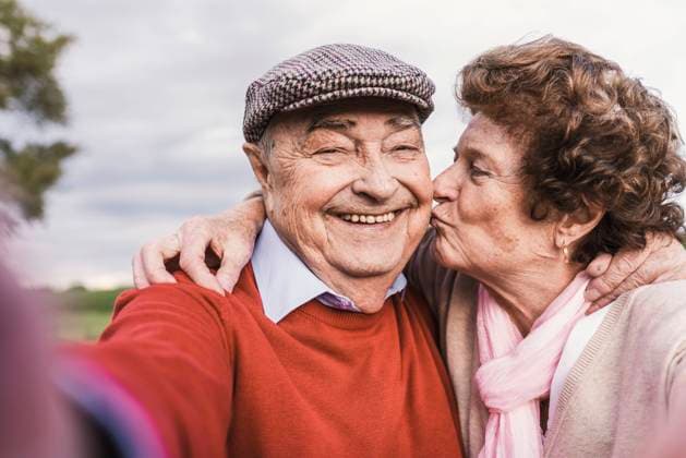Creative Highlights Symbolbilder Happy senior woman kissing man on cheek model released, Symbolfoto, UUF30735