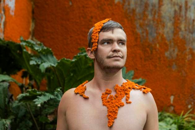 Creative Highlights Symbolbilder Thoughtful young man with orange moss in front of wall model released, Symbolfoto, WVF02051