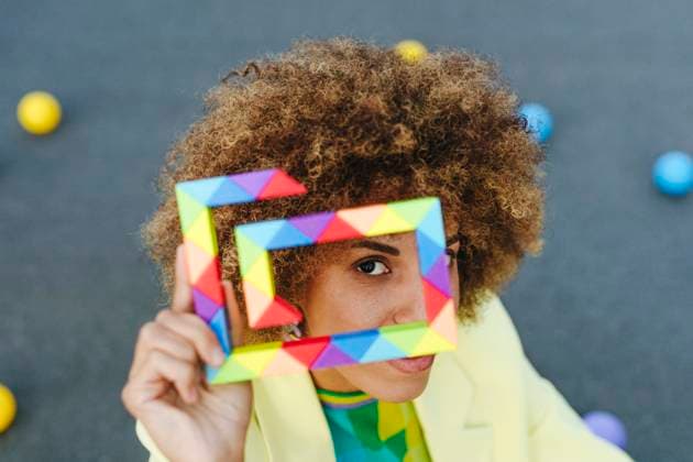 Creative Highlights Symbolbilder Woman with curly hair looking through colorful toy model released, Symbolfoto property released, YTF01428