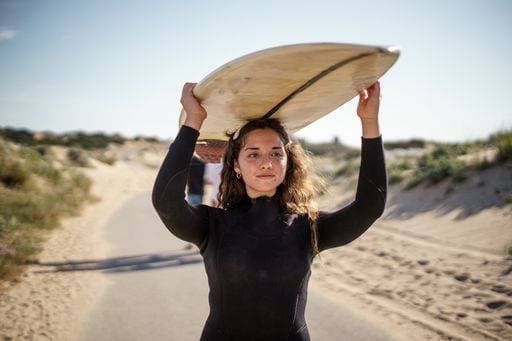 A shallow focus shot of a European female holding a surfboard and walking to the beach 642266 ,model released, Symbolfoto RECORD DATE NOT STATED