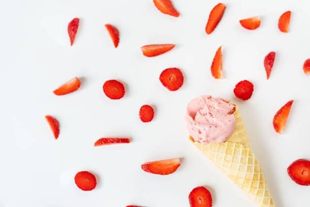 Strawberry ice cream in a waffle cup in the form of a cone, ice cream lies on a white table along with slices of fresh strawberries. Strawberry ice cream in a waffle cup in the form of a cone, ice cream lies on a white table along with slices of fresh strawberries Copyright: xZoonar.com SergiyxArtsabax 20400777