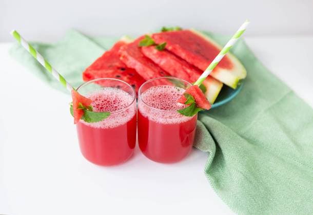 Juicy freshly squeezed watermelon juice in a glass along with a green tube, against a green napkin. Juicy freshly squeezed watermelon juice in a glass along with a green tube, against a green napkin Copyright: xZoonar.com SergiyxArtsabax 20468342