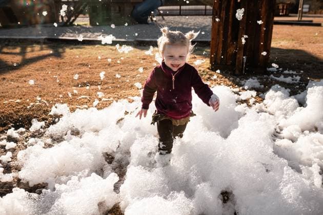 Creative Highlights Symbolbilder Young child playing in foam bubbles outdoors at park Murfreesboro, Arkansas, United States CR_WEKW23122978-1313832-01 ,model released, Symbolfoto