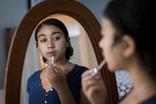 Biracial Teen Girl Puts on lipgloss in the mirror Harwich, Massachusetts, United States CR_JUCU240107-1306059-01 ,model released, Symbolfoto