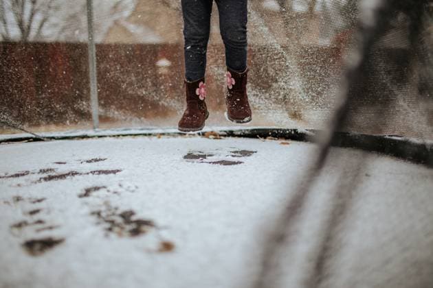 Feet of young child jumping on trampoline in snow Aurora, Colorado, United States R_JEMI240114E-1244955-01 ,model released, Symbolfoto