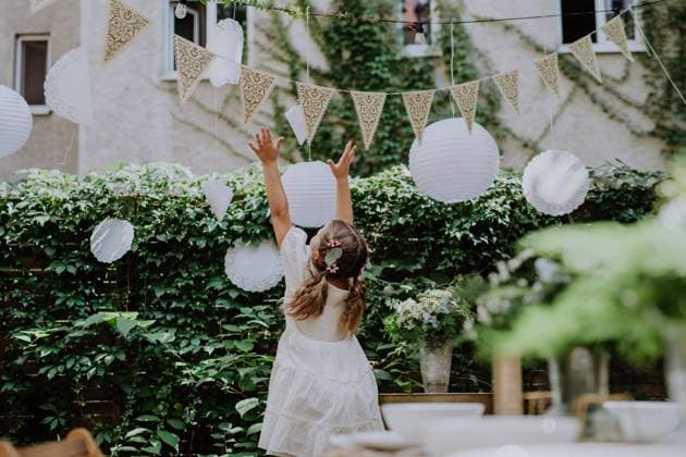 Rear view of happy little child playing with wedding decorations. Rear view of happy little child playing with a wedding decorations. model released Copyright: xx HHH BACKYARD WEDDING 2022 HHH 039