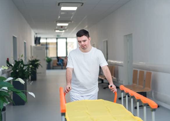 IMAGO Creative, Diversity, Pflege im Krankenhaus Young man with down syndome working in hospital as caregiver. Concpet of integration people with disability into society. Young man with down syndome working in a hospital as a caregiver. Concpet of integration people with disability into society. model released Copyright: xx HHH BOJNICE HOSPITAL HELPER 2022 HHH 086