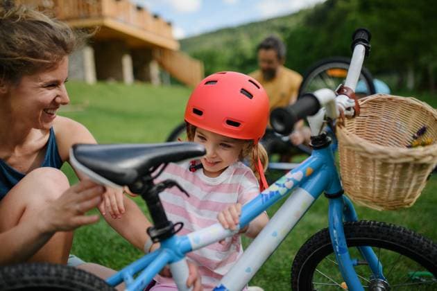 Young family with little children preaparing for bike ride, in front of house. A young family with little children preaparing for bike ride, in front of house. model released Copyright: xx HHH FAMILY BIKING BODOVCI 2022 HHH 073