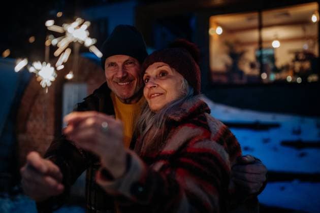 Happy senior couple celebrating new year with sparklers, enjoying winter evening. Happy senior couple celebrating new year with the sparklers, enjoying winter evening. model released Copyright: xx HHH SENIOR WELLNESS 2022 HHH 151