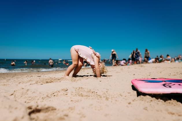 Creative Highlights Symbolbilder Young child doing downward dog yoga on crowded beach Chesterton, Indiana, United States CR_WEKW240116-1328142-01 ,model released, Symbolfoto