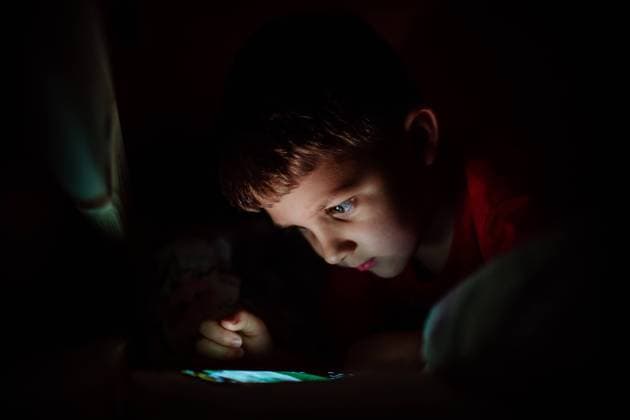 Addicted little boy playing games on phone in bed at night. An addicted little boy playing games on phone in bed at night. model released Copyright: xx HHH SOLO TZ LUCKA KIDS CITY 2022 HHH 301