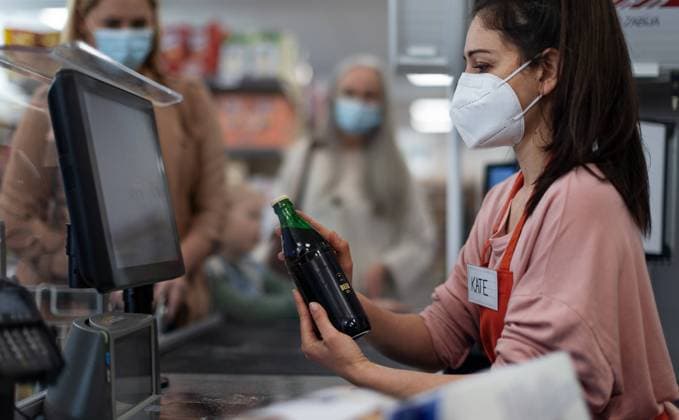 Checkout counter cashier scans bottle in supermarket. A checkout counter cashier scans bottle in supermarket. model released Copyright: xx I65A9428