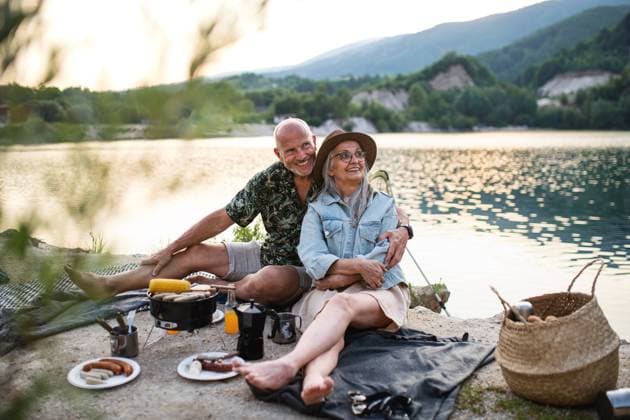 Happy senior couple resting on summer holiday trip, barbecue by lake. Portrait of happy senior couple resting on summer holiday trip, barbecue by lake. model released Copyright: xx Family_Lake_Holidays_2021_287
